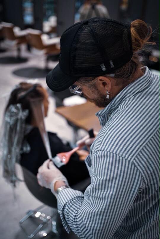 A Red Market colorist hand-painting balayage freehand — no foils — at the West Palm Beach salon