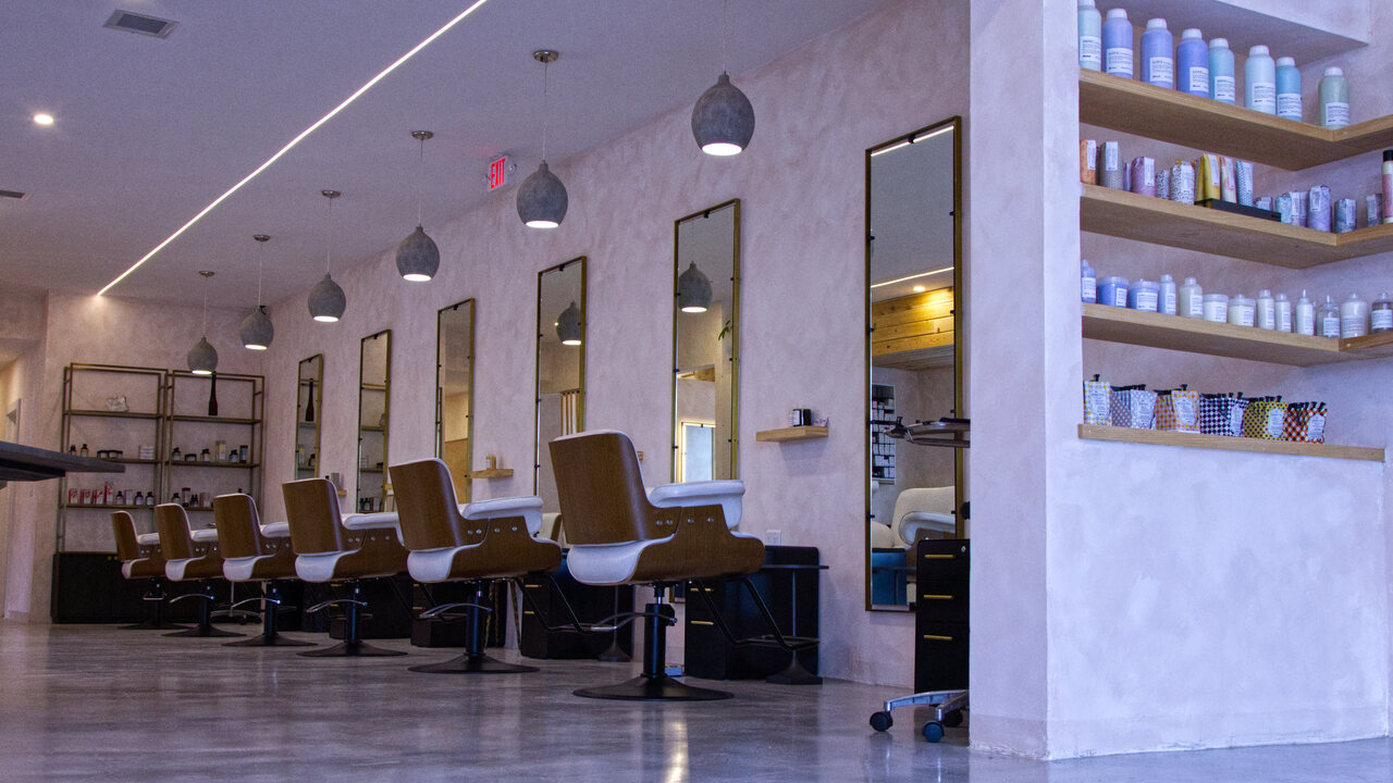 The styling floor at Red Market & Martial Vivot — chair row, pink walls, pendant lights
