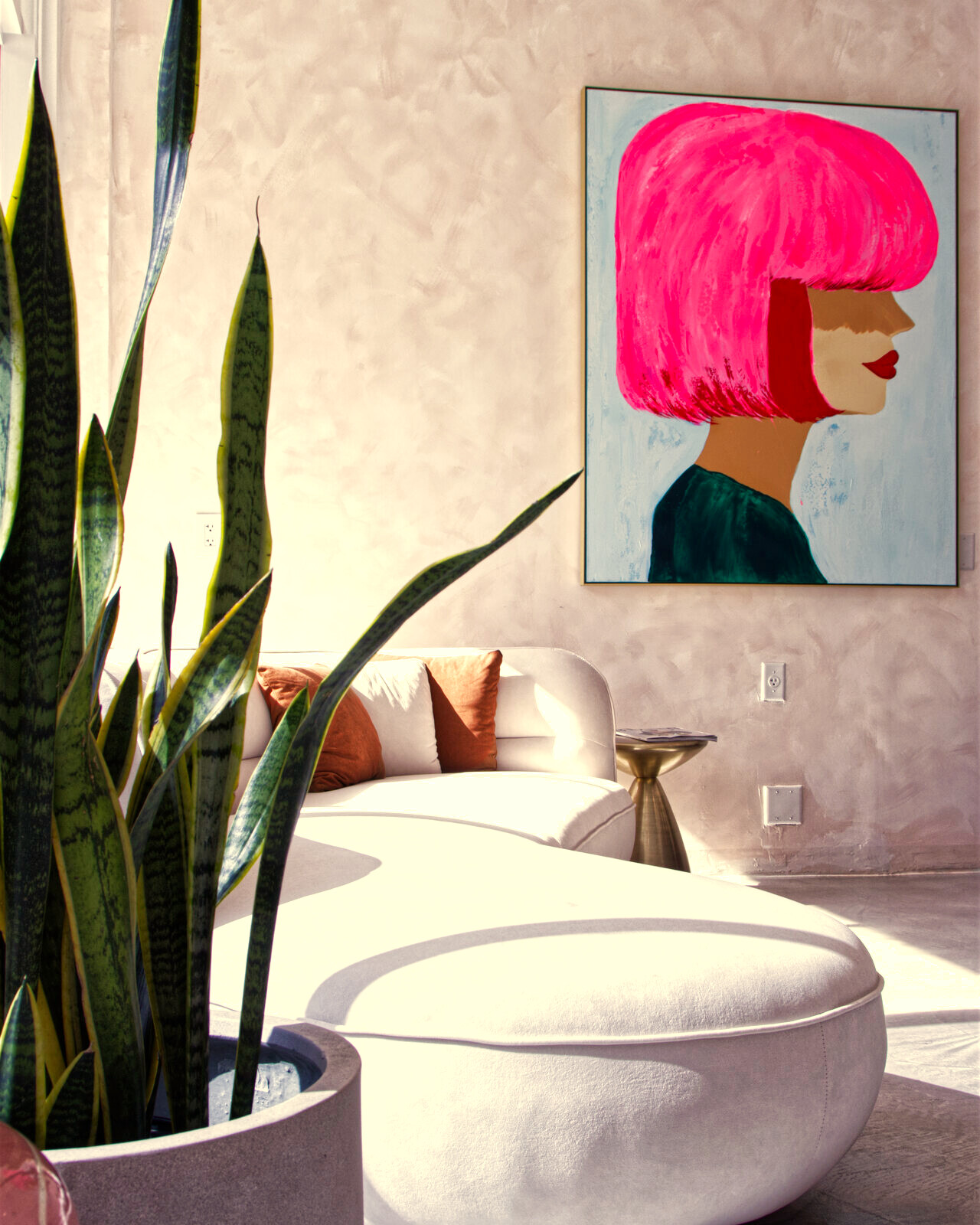 Red Market & Martial Vivot lounge — pink-plaster walls, curved white settee, brass mirror