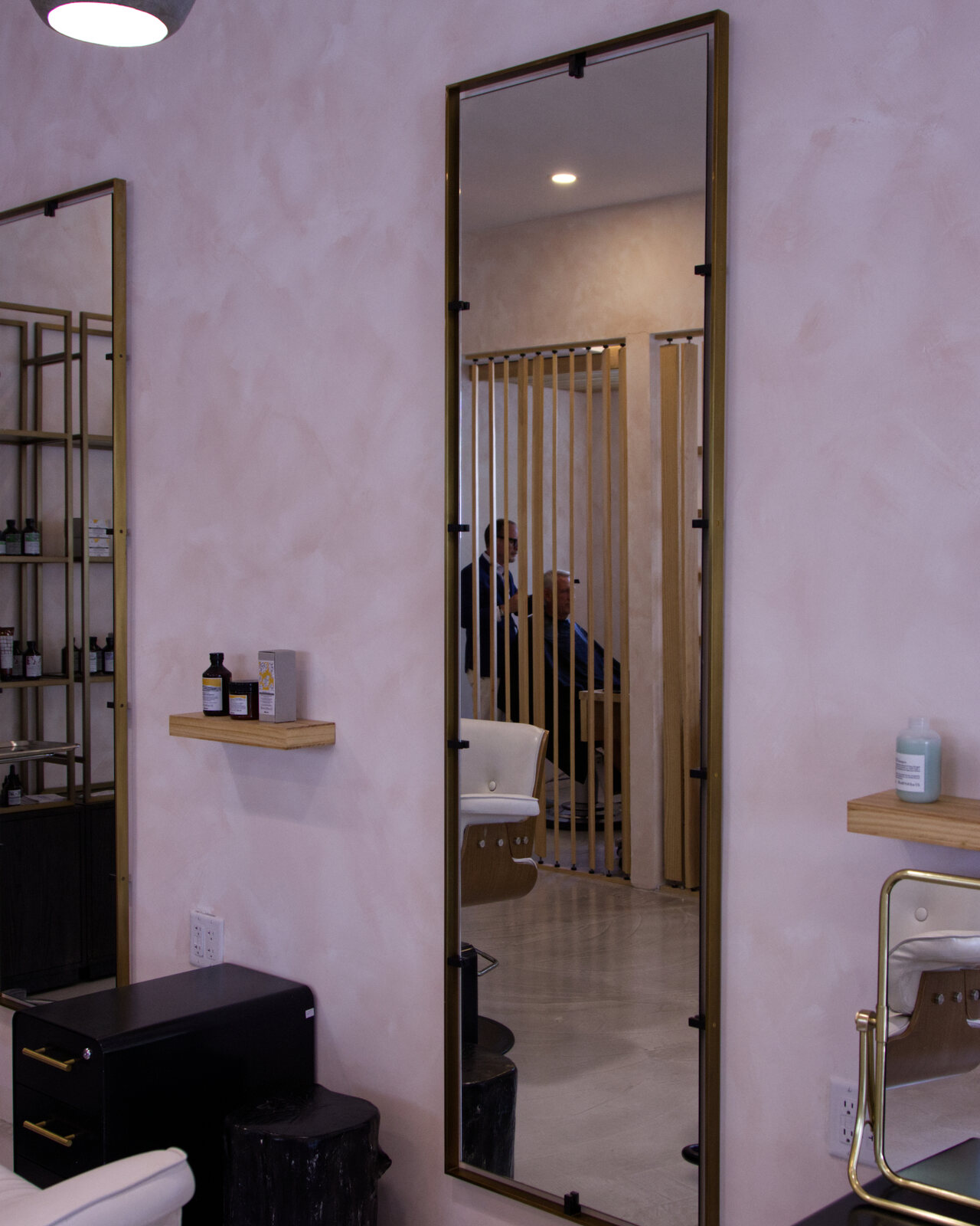 Pink-plaster wall with brass-framed mirror reflecting the salon — Red Market & Martial Vivot