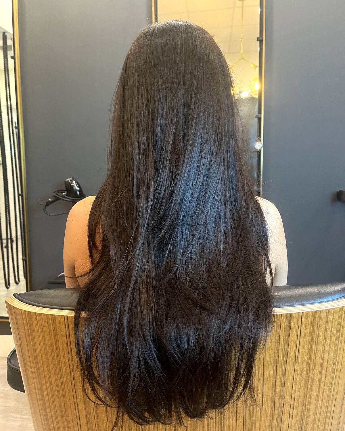 A finished women's haircut at Red Market & Martial Vivot — long dark hair cut into soft layers with a clean, blunt perimeter